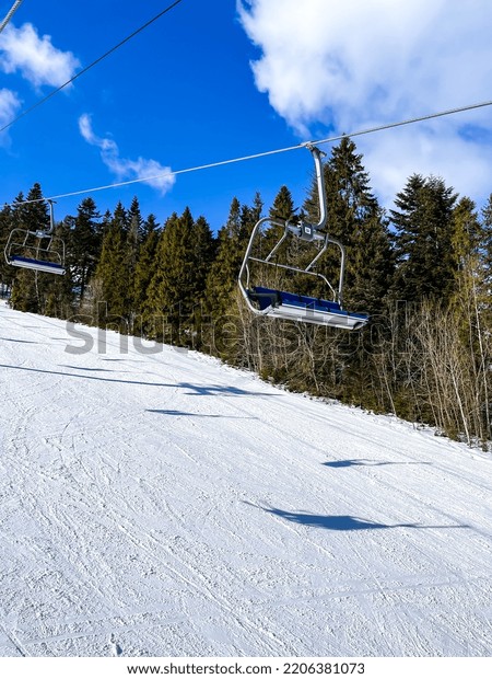 Ski Lift snowy mountain\
winter forest with chair lift At The Ski Resort in winter. Snowy\
weather Ski holidays Winter sport and outdoor activities Outdoor\
tourism 