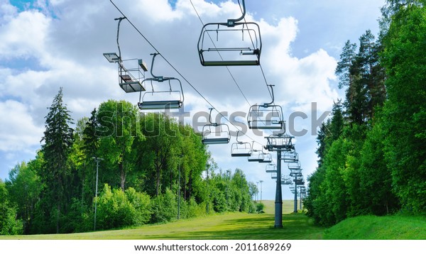 Ski lift in the summer\
against the blue sky. Deserted ski complex during the off-season.\
The chair lift with empty cabins does not work on a sunny summer\
day.