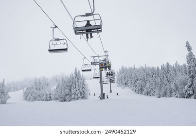 Ski Lift in Winter Wonderland: Skiers Ascend Snow-Covered Mountain Amidst Frosty Trees and Serene Winter Landscape - Powered by Shutterstock