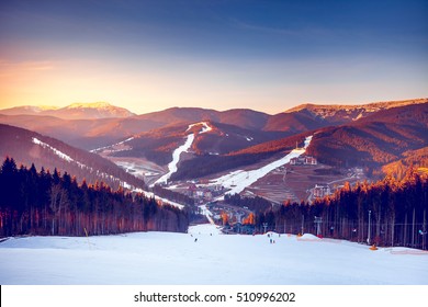 Ski Resort In Beautiful Sunset Light. View From The Top: Ski Tracks, Pine Tree Forest And Mountains In The Background. Winter Holidays In Bukovel, Carpathians, Ukraine, Europe