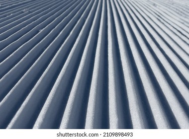 Ski resort. Fresh corduroy on the slopes. Ripples in snow covered landscape. Perfectly groomed empty ski piste. Winter sports.