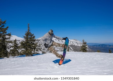 Ski Resort. Snowboarder Jumping On A Snowboard In The Mountain. Long Jump On A Snowboard.