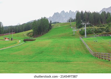 Ski resort in the summer . Green meadow and ski resort in Italian Alps 