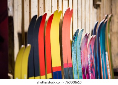 Ski shop sale. Rows of  colourful skis on wooden wall. 