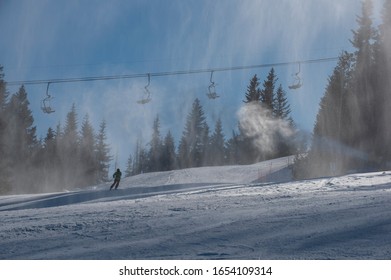 Ski Slope With Artificial Snow Machine And Skiers