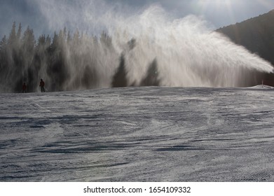 Ski Slope With Artificial Snow Machine And Skiers