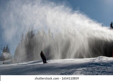 Ski Slope With Artificial Snow Machine And Skiers