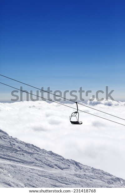 Ski slope, chair-lift and\
mountains under clouds. Ski resort Gudauri. Caucasus Mountains,\
Georgia. 