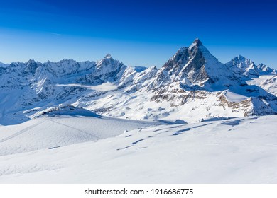 Ski slope and snow covered winter mountains. Matterhorn is a mountain in the Pennine Alps on the border between Switzerland and Italy - Shutterstock ID 1916686775