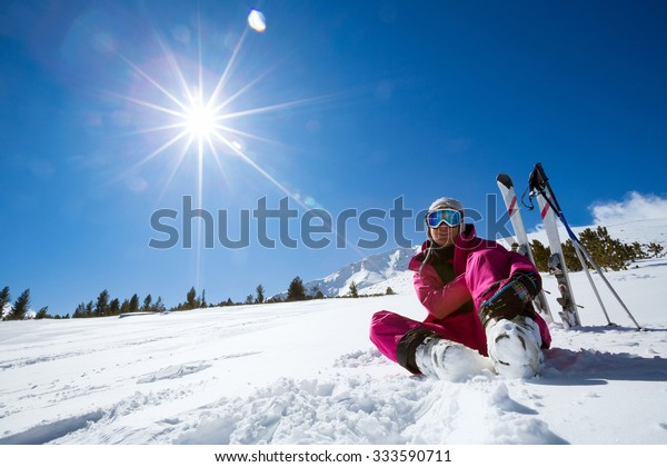 Ski,\
snow and sun - resting female skier in winter\
resort