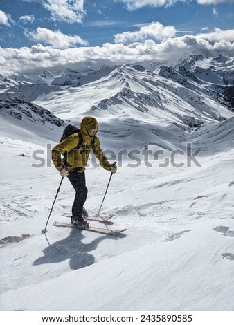 Ski tour during a storm on the Wissmeilen with the mountain Spitzmeilen in the background. Ski mountaineering near Flumserberg. Young man fights against the wind. High quality photo