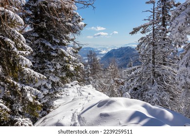Ski tour trail leading to Kobesnock in Bad Bleiberg, Carinthia, Austria, Europe. Scenic view of snow capped mountain peak Dobratsch, Julian Alps and Karawanks. Winter wonderland landscape on sunny day