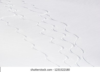 Ski tracks on the background of snowy mountains. Off-piste skiing in soft snow on a cold sunny day. Snow's  pattern.  - Shutterstock ID 1231522180