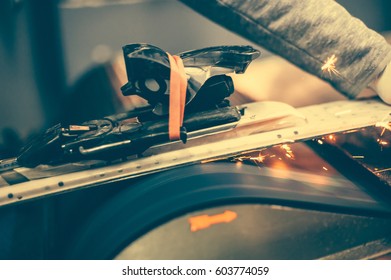 Ski Tuning And Repairs. Winter Shop Worker Doing Base Repair. Rental Workshop Service