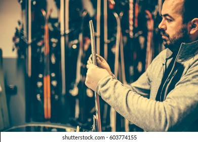 Ski Tuning And Repairs. Winter Shop Worker Doing Base Repair. Rental Workshop Service