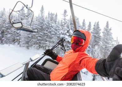 Ski vacation - skier in ski lift taking selfie photo or video using mobile phone. Ski winter vacation concept. Skiing on snow slopes in mountains, Woman having fun on snowy day. Winter sport activity.