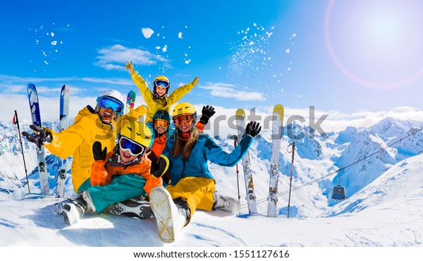 Ski in winter season,\
mountains and ski family on the top in sunny day in France, Alps\
above the clouds.\
