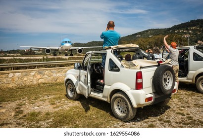 Skiathos, Greece - May 09, 2014, People Watching Airplane Preparing To Take Off On The Island Of Skiathos In Greece