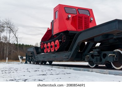 skidder on a railway flatcar against the background of a winter forest 