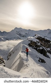 Skier Choosing His Line Heliskiing On Steep Ridge Mountains Around