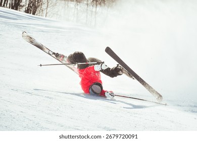Skier fall down hit head painfully on hard groomed piste with snow swirls on ski resort slope. Sports Injury young skier in professional sports concept.. Reckless