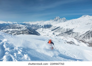 A skier is freeriding against the background of the peaks of Mount Ushba, the Great Caucasian Range in winter, - Shutterstock ID 2249447763