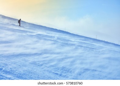 Skier on the windy winter track during orange sunset - Shutterstock ID 573810760