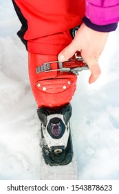 Skier In Red Ski Suit And Red Ski Boots And White Skis, Closeup.