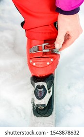 Skier In Red Ski Suit And Red Ski Boots And White Skis, Closeup.