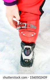 Skier In Red Ski Suit And Red Ski Boots And White Skis, Closeup.