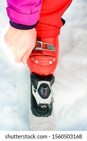 Skier In Red Ski Suit And Red Ski Boots And White Skis, Closeup.