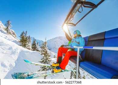 Skier Sitting At Ski Chair Lift In Beautiful Sunny Day, Alpine Mountains. Concept Of Skiing