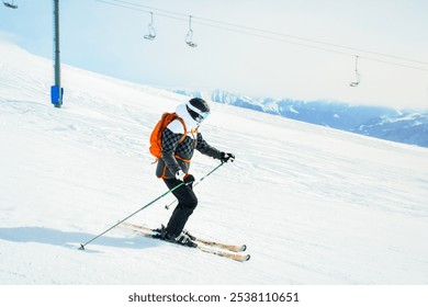 Skier ski down snowy slope with mountains background - Powered by Shutterstock