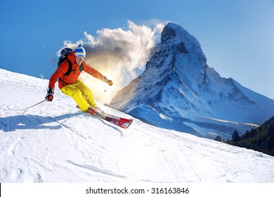 Skier Skiing Downhill Against Matterhorn Peak In  Switzerland