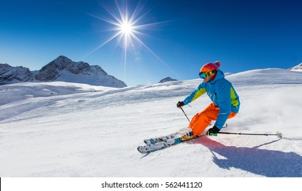 Лыжник катается на горных лыжах в солнечный день в высоких горах