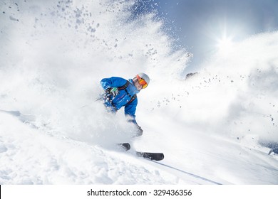 Skier Skiing Downhill In High Mountains