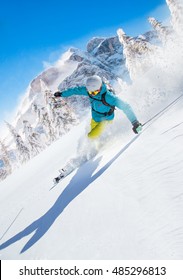 Skier Skiing Downhill In High Mountains