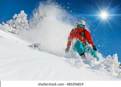 Skier Skiing Downhill In High Mountains