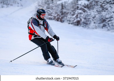 Skier skiing downhill in winter mountains