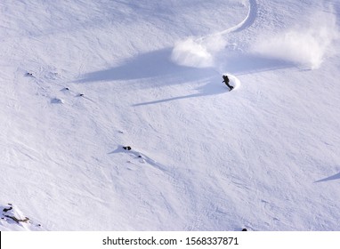 Skier Snowboarder Riding Through Field Of Powder