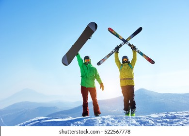 Skier and snowboarder stands mountain top with ski and snowboard in hands. Skiing and snowboarding concept. Sheregesh ski resort