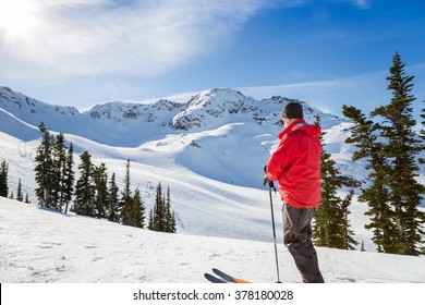 Skier standing in front of Whistler Mountain peak. 