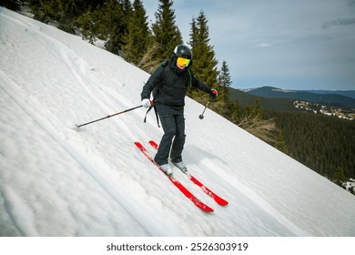 A skier swiftly carves down a snowy slope, the bright red skis contrasting against the white snow and evergreen forest. - Powered by Shutterstock