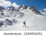 A skier walks in the mountains