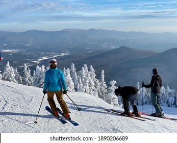 Skiers getting ready to ski down the slopes at beautiful snow day at the Stowe Mountain Ski resort Vermont - December 2020