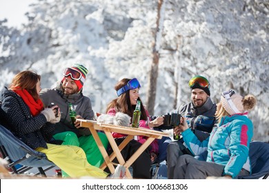 Skiers Group Refreshing With Drink After Skiing In Cafe On Ski Terrain  