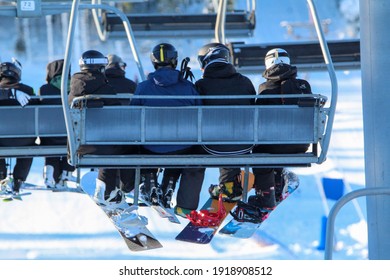Skiers on a lift in ski resort.