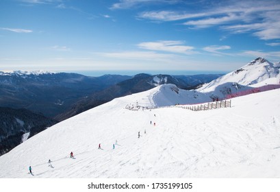 Skiers On The Ski Track In Krasnaya Polyana On The Background Of Winter Caucasus Mountains. Sochi, Krasnodar Krai