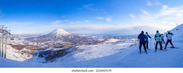 Skiers seeing a snowy volcano in late afternoon (Niseko, Hokkaido, Japan) - Powered by Shutterstock