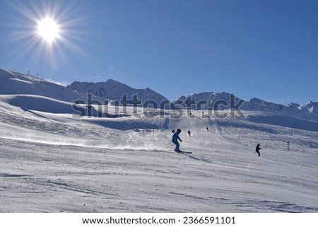 Skiers and snowboarders in Hochgurgl on a beautiful sunny day, perfect conditions for winter sport, skiing and snowboarding in the snowcapped alpine mountains in the Ötztal valley, Tyrol, Austria.